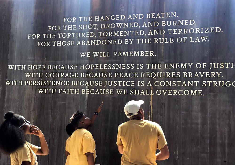 Students read the dedication statement at the National Memorial for Peace and Justice.