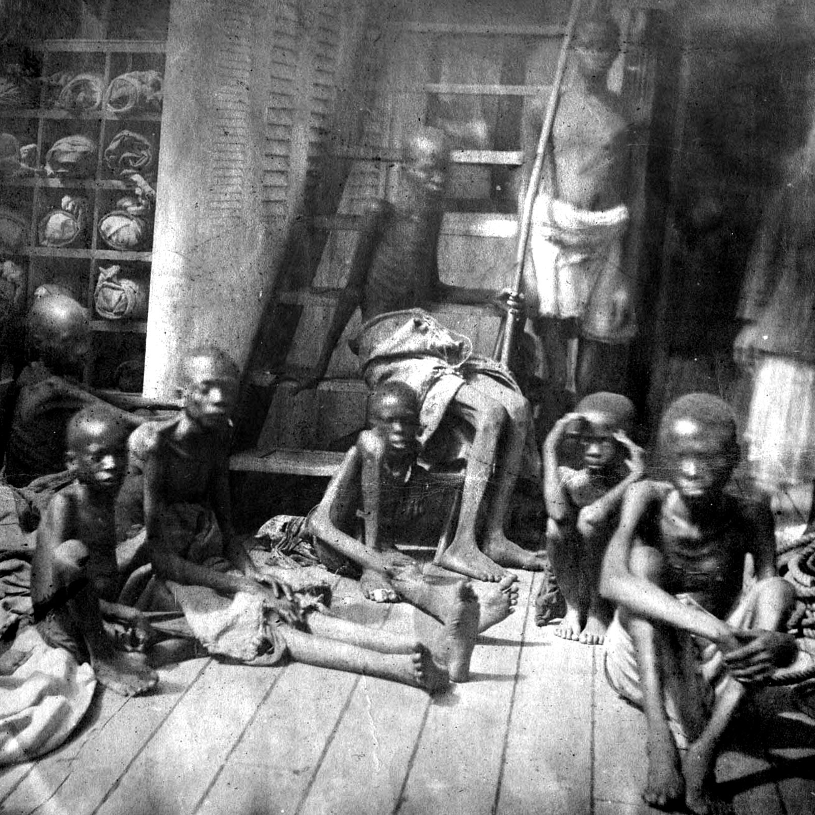 Starving children wearing scraps of clothing who were rescued from a trafficker's ship.