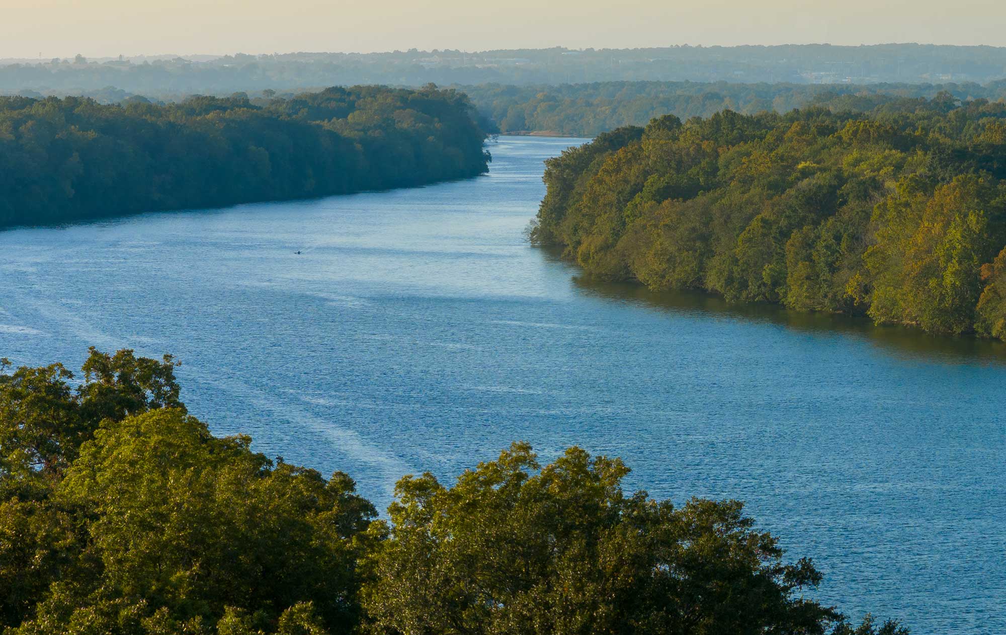 Aerial view of a bend in the Alabama River showing river banks covered with lush green foliage.