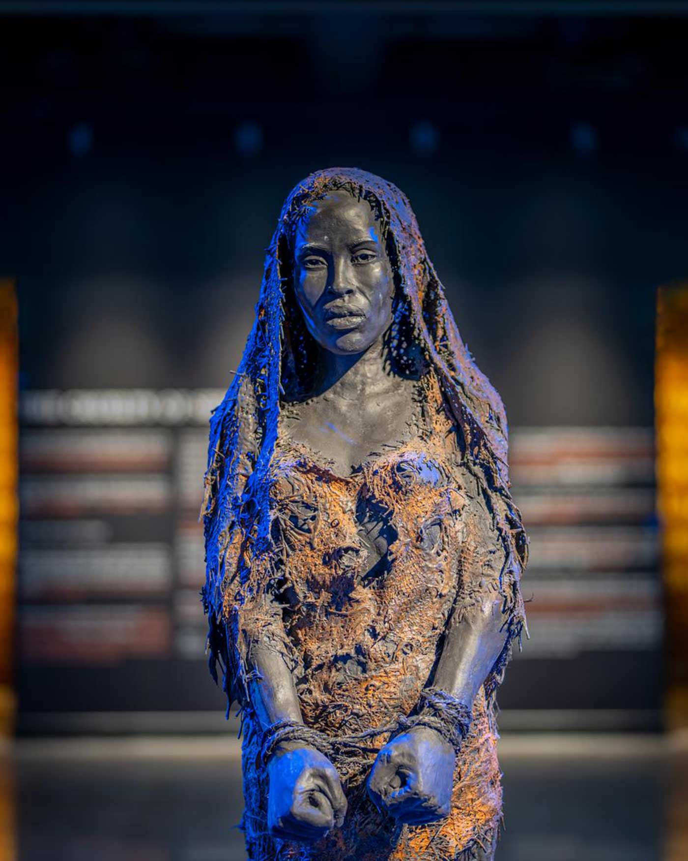 Sculpture of an enslaved woman with her wrists bound called Exode, No Home by Sandrine Plante in the Legacy Museum.