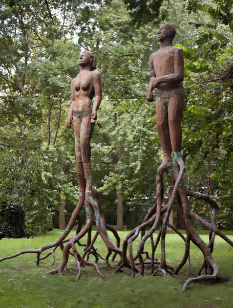 Sculpture of a man and a woman with tree roots extending down from their feet, rooting them in the earth.